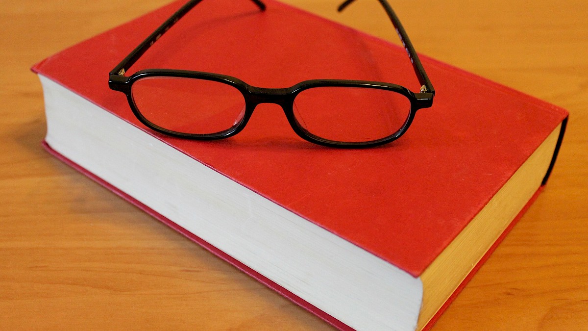 Brille liegt auf Buch